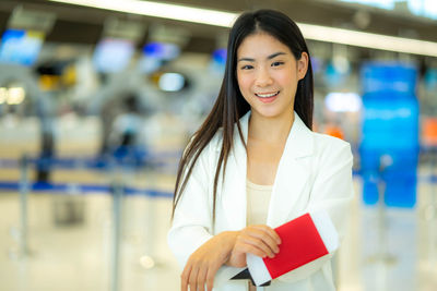 Portrait of young woman standing in supermarket