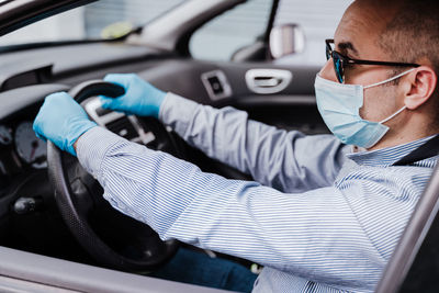 Close-up of man wearing mask sitting in car