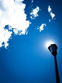 Low angle view of street light against blue sky