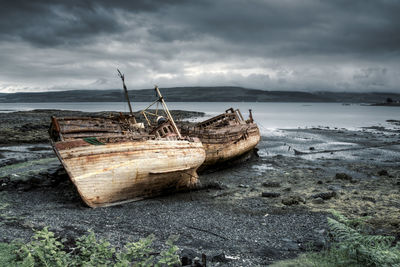 Fishing boat on beach against sky