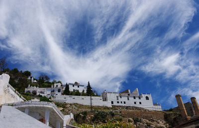 Buildings in city against cloudy sky