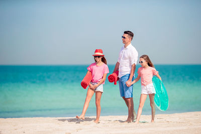 Father with daughters walking on beach