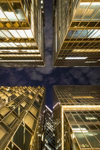 Low angle view of illuminated buildings against sky at night