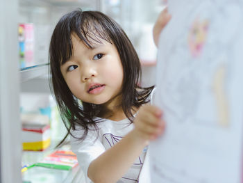 Close-up of girl looking at drawing in home