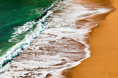 High angle view of waves rushing towards shore