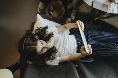 High angle view of girl using tablet pc while traveling in train