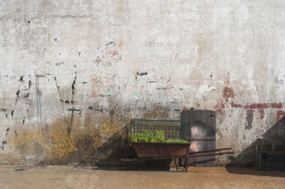 Abandoned chair against wall