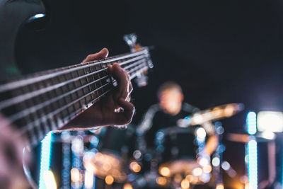 Cropped image of man playing guitar at music concert