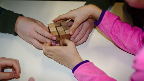 Close-up of hands holding girl playing