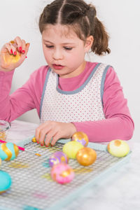 Portrait of cute girl playing with toys against white background