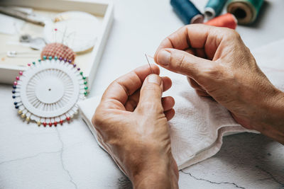 Hands threading sewing needle