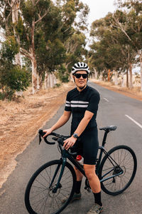 Young woman with bicycle on road