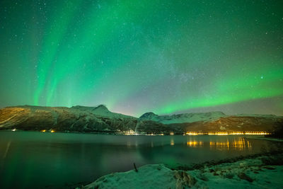 Scenic view of lake against aurora borealis during winter