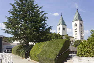 Panoramic view of trees and building against sky