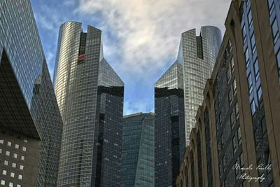 Low angle view of buildings against cloudy sky