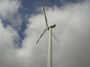 Low angle view of windmill against cloudy sky