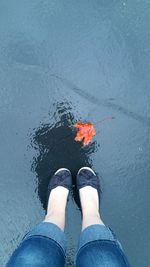 Low section of person standing in water