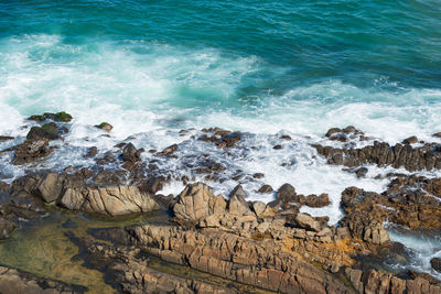 Ocean waves breaking on the rocks on the beach. salvador, bahia, brazil.