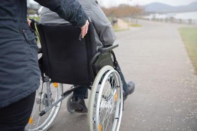 A woman pushes a disabled person in a wheelchair