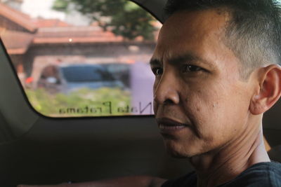 Close-up of thoughtful mature man in car