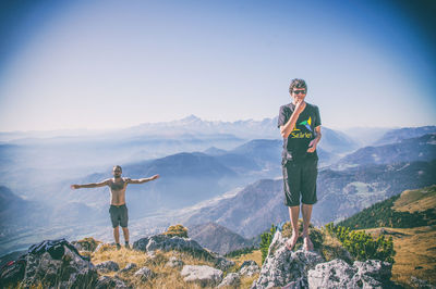 People standing on mountain against sky