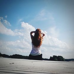 Woman standing by tree against sky
