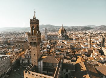 Aerial view of buildings in city against sky