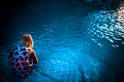 Rear view of child at swimming pool