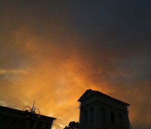 Low angle view of silhouette building against sunset sky