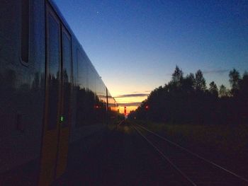 Railroad track against sky at sunset