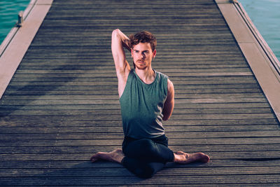 Young man exercising on boardwalk