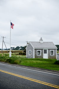 Flag by built structure against sky