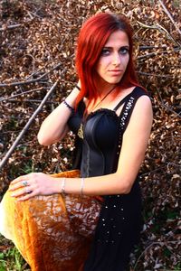 Portrait of young woman standing in autumn leaves