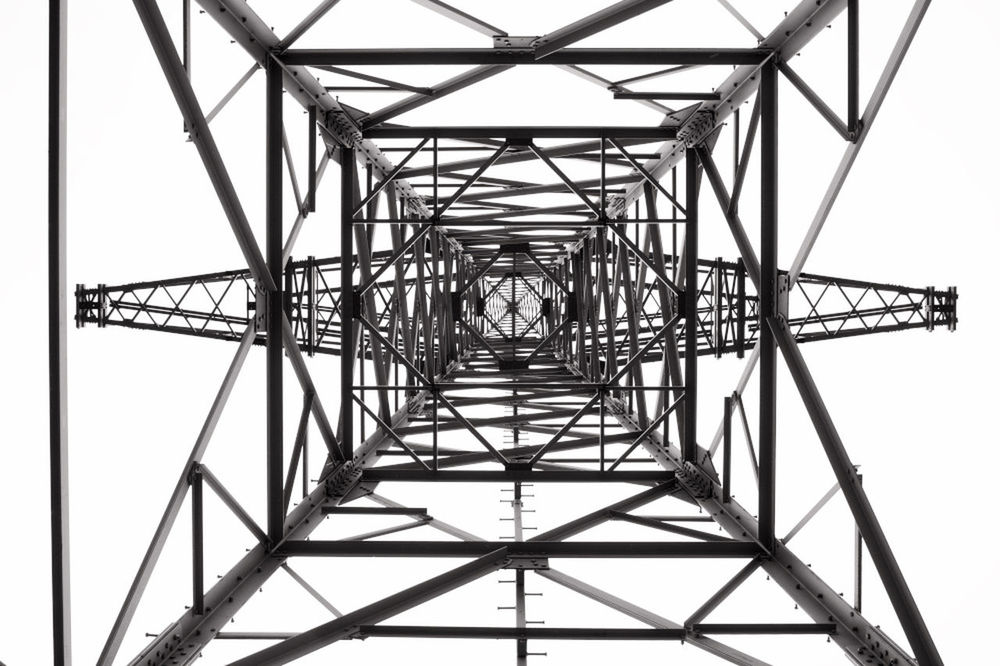 architecture, built structure, sky, metal, connection, low angle view, day, nature, clear sky, real people, men, outdoors, one person, pattern, directly below, diminishing perspective, engineering, bridge, grid, electricity, power supply, complexity