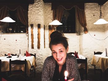 Portrait of smiling young woman sitting at restaurant