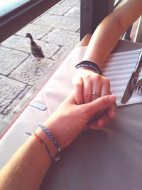 Cropped hand of couple holding hands on table