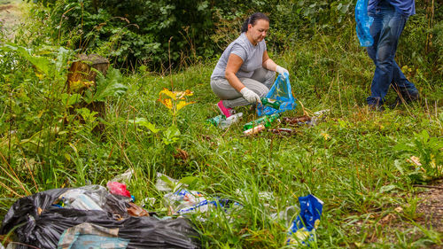Woman clean up garbage dump in the park. horizontal photo
