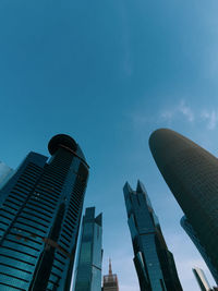 Low angle view of modern buildings against blue sky