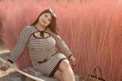 Portrait of a smiling young woman sitting outdoors