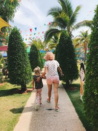 Rear view of people against trees