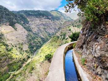 Scenic view of river amidst mountains against sky