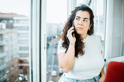 Young woman talking on phone at office