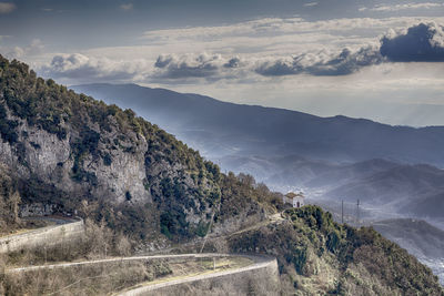 Scenic view of road by mountains against sky