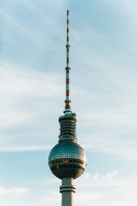 Low angle view of communications tower against sky in city