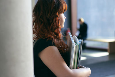 Midsection of woman holding book