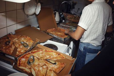 Boxes with pizza in kitchen