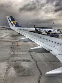 Airplane on airport runway against sky