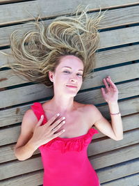 High angle portrait of woman lying on hardwood floor