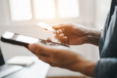 Midsection of man holding mobile phone