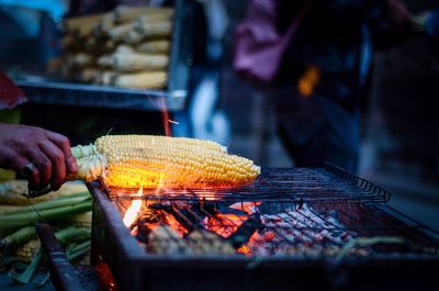 Person roasting corns on barbecue grill